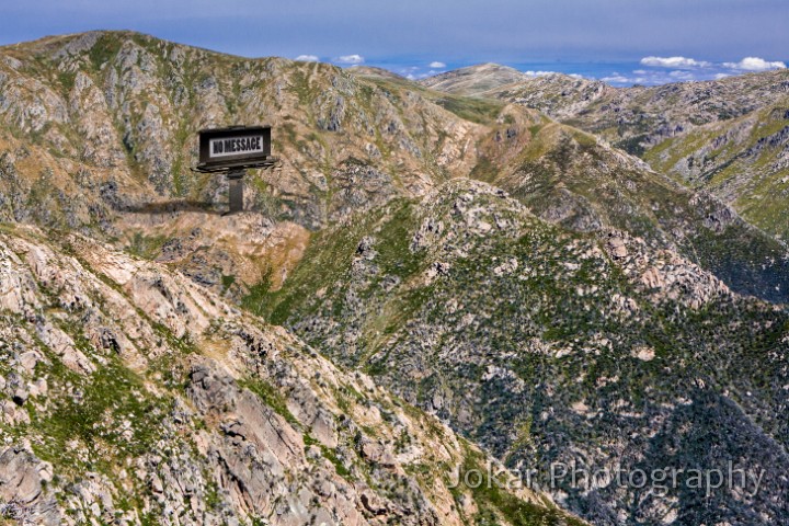 Watson Crags-2.jpg - Watson's Crags. Watson’s Crags lie on the steep western side of the Kosciuszko Main Range, between Mt Twynam and Mt Townsend. It’s a rugged and rarely visited part of the mountains, several hours walking or skiing from the nearest road or ski-lift access. In winter some intrepid skiers brave the steep slopes, and in summer there’s an occasional backcountry bushwalker, but mostly it’s left undisturbed by humans. Unlike much of the region, people have made no claim to the land, haven’t tried to ‘make use of it’, and are content to just let it ‘be’. So if this land could speak, I imagine that it might talk with its own voice, unsullied by any accretions of human projections or aspirations. In this image, a massive billboard allows the land to speak to us with its own voice, and its message is…. “No Message”.